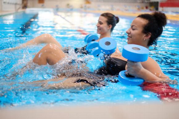 two women in pool with water weights