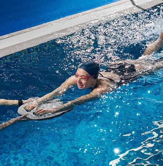 lady learning to swim in pool with float