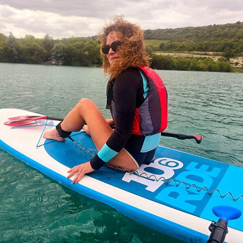 Katie sitting on surfboard in the water